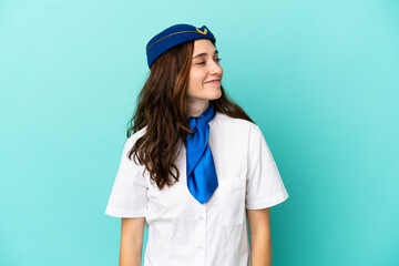 Airplane stewardess woman isolated on blue background looking side