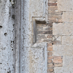 Italy, Perugia, summer 2022. Fragment of a wall with brick and stone inlays. Geometric ornamentation can be seen on the left