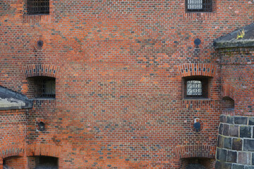 Wall old brick fortress with loopholes.