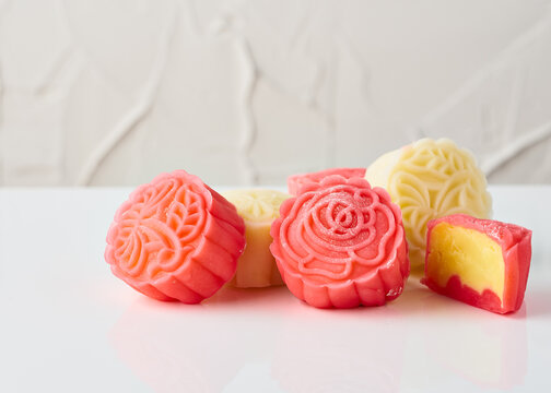 This is a close-up image of a traditional mooncake, showcasing intricate detail. The mooncake is sculpted with a floral pattern, resembling a blooming rose, indicative of the artistry involved in its 