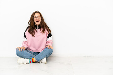 Young caucasian woman sitting on the floor isolated on white background with surprise facial expression