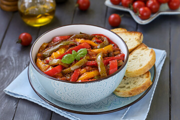 Italian sweet pepper stew Peperonata. Stewed red, yellow and green bell peppers with olive oil,...