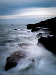 Fototapeta premium San Diego Seascape Series, dramatic cloudscape with stormy white seafoam splashing to the cliff at Sunset Cliffs in Cabrillo National Monument, Southern California, USA
