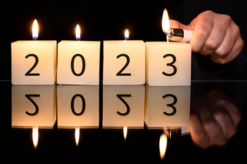 Happy new year background. A girl lights candles with 2022 numbers. 