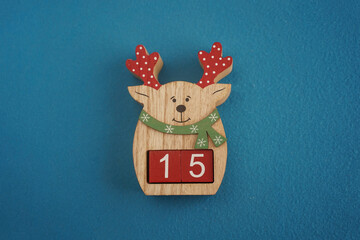 Festive wooden deer Viva Magenta cubes 15 blue background close-up top view. Christmas concept date...