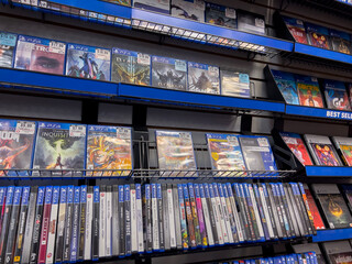Naklejka premium Seattle, WA USA - circa December 2022: Selective focus on used video games for sale inside a GameStop gaming store.