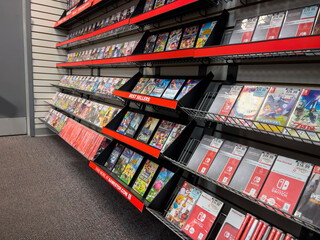 Fototapeta premium Seattle, WA USA - circa December 2022: Selective focus on used video games for sale inside a GameStop gaming store.