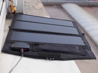 Fensterbank - faltbares Solarpanel lädt Powerbank auf	