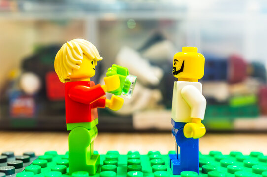 A Lego man figurine taking a photo with a camera of a other person.