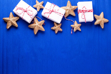 Frame  from wrapped boxes with presents  and golden decorative stars on blue paper  textured  background. Place for text. Flat lay. Holiday layout. - 554314264