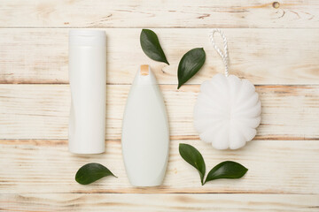 Shower gel with washcloth on wooden background, top view