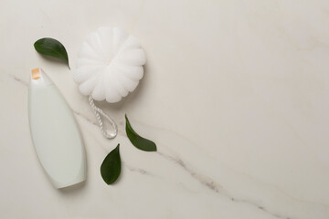 Shower gel with washcloth on marble background, top view