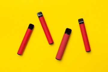 Disposable electronic cigarettes on color background, top view