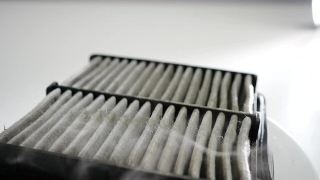 a old and dirty dusty car air filter rotation close-up