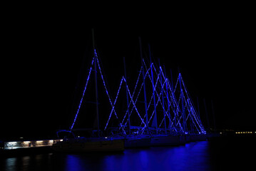 Christmas atmosphere and cityscape of the city of Volos with blue lights illuminating the boats and sailboats, decorating the beautiful beach town. Volos Magnesia, Greece