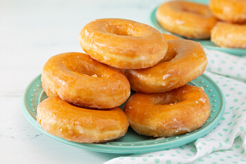 Glazed doughnuts on an aqua colored plate