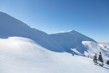 Fototapeta na wymiar Winter in mountains. Alpine mountains landscape with white snow and blue sky.