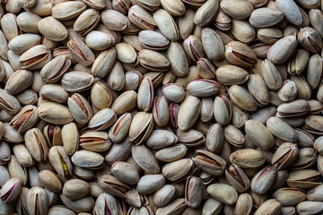 Pistachios texture and background. Pile pistachio kernels nuts with shell, closeup. Pistachio nuts. Whole nut kernels