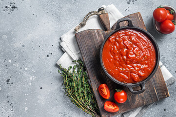 Homemade red tomato sauce with basil in pan. Gray background. Top view. Copy space