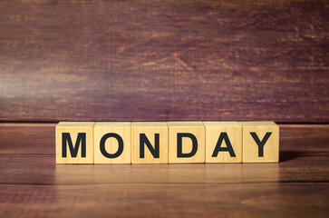 monday word on wooden blocks and brown background
