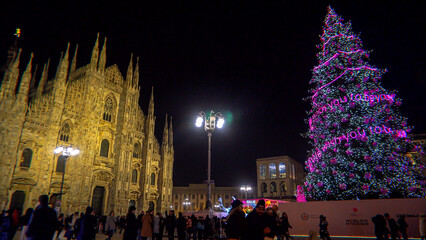 Panorama of the Piazza Duomo square on the New Year and Christmas tree. Albero di Natale with colored lights. City at night. One night ahead. Multi-colored lights. Milan, Italy, December 2022