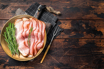 Dry cured pork Black Forest Ham bacon with rosemary. Wooden background. Top view. Copy space - obrazy, fototapety, plakaty