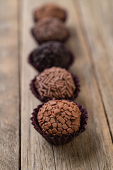 Typical brazilian chocolate brigadeiros over wooden table, short depth of field