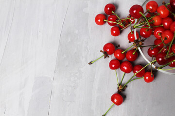 cherry red berry scattered on a gray background. Top view with space for text and copyspace. Summer seasonal berry