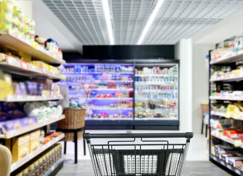 choosing a dairy products at supermarket.empty grocery cart in an empty supermarket,frozen food from a supermarket freezer