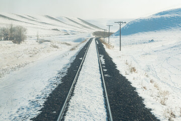 winter season and train journey , train tracks taken from the back of the train and snowy background photo