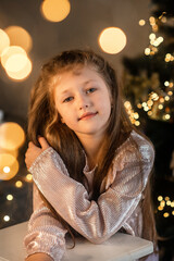 Portrait of a little girl behind the  christmas tree