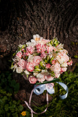 Obraz na płótnie Canvas Wedding bouquet of the bride with flowers, tree in the background. Bridal bouquet with white and pink flowers