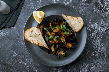 Mussels in wine sauce top view on dark table