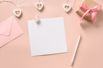 Valentine's day greeting card with hearts, blank, pink envelope and gift on pink background. View from above. Copy space.