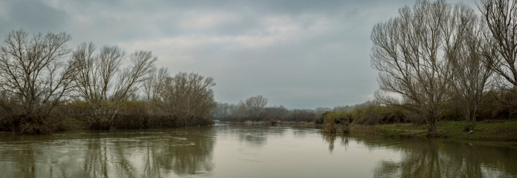 Shoreline reflections in a tranquil river scene, Ebro River, Spain; Benissanet, Tarragona, Spain