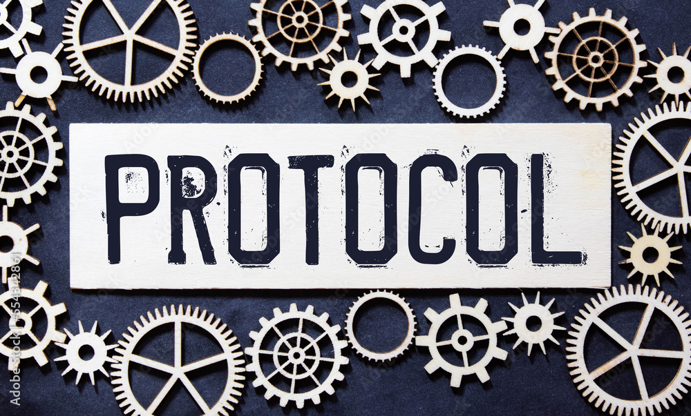 Poster text protocol is written on a folder lying on a stack of papers with a pen on the table.