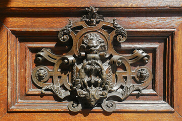 Front door lock in France on door in gold with angry face