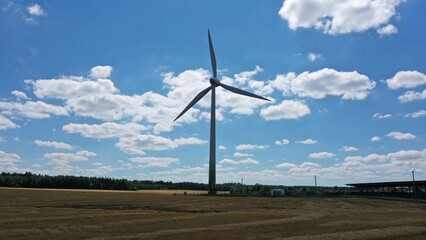 Huge windmill against the blue sky in summer. Extraction of wind energy. Ecological turbine. Free electricity. The energy of the future.