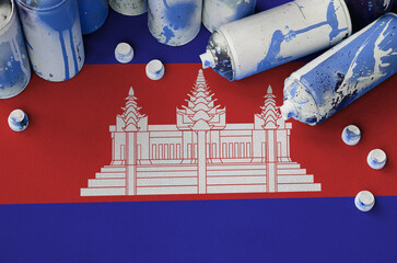 Cambodia flag and few used aerosol spray cans for graffiti painting. Street art culture concept,...