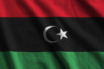 Libya flag with big folds waving close up under the studio light indoors. The official symbols and...