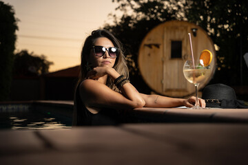 Mujer en piscina con un cocktail - obrazy, fototapety, plakaty