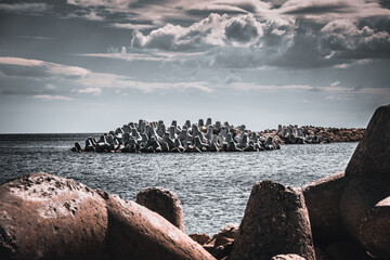 Wellenbrecher aus Beton an der Küste im Meer