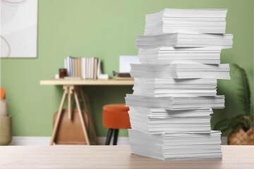 Stacked sheets of paper on wooden table in office, space for text