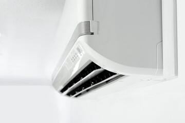 Modern air conditioner on white wall indoors, closeup. Space for text