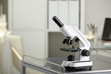 Modern medical microscope on metal table in laboratory, space for text