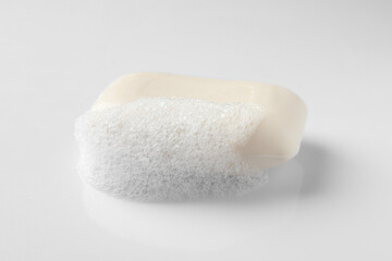 Fototapeta na wymiar Soap with fluffy foam on white background