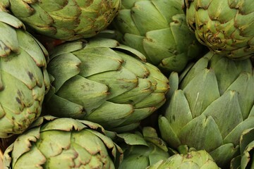 Obraz premium Many fresh raw artichokes as background, top view