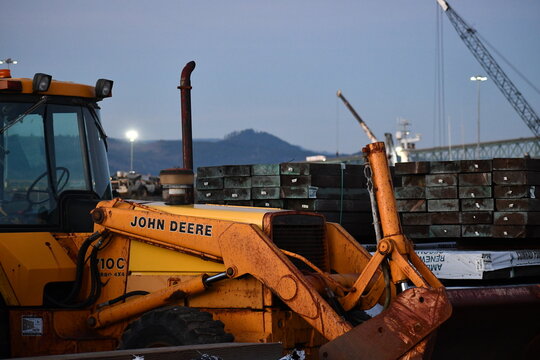 John Deere tractor sits at the Port of Astoria, evening time.