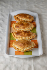 Top view of argentinian empanadas baked on a platter.
