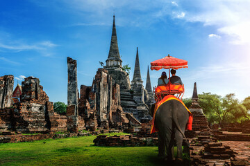 Couple on a ride elephant tour of the ancient city in ayutthaya, thailand. - obrazy, fototapety, plakaty